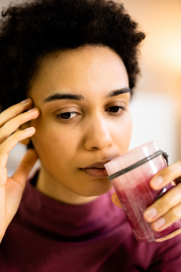 an african american women is smelling a candle